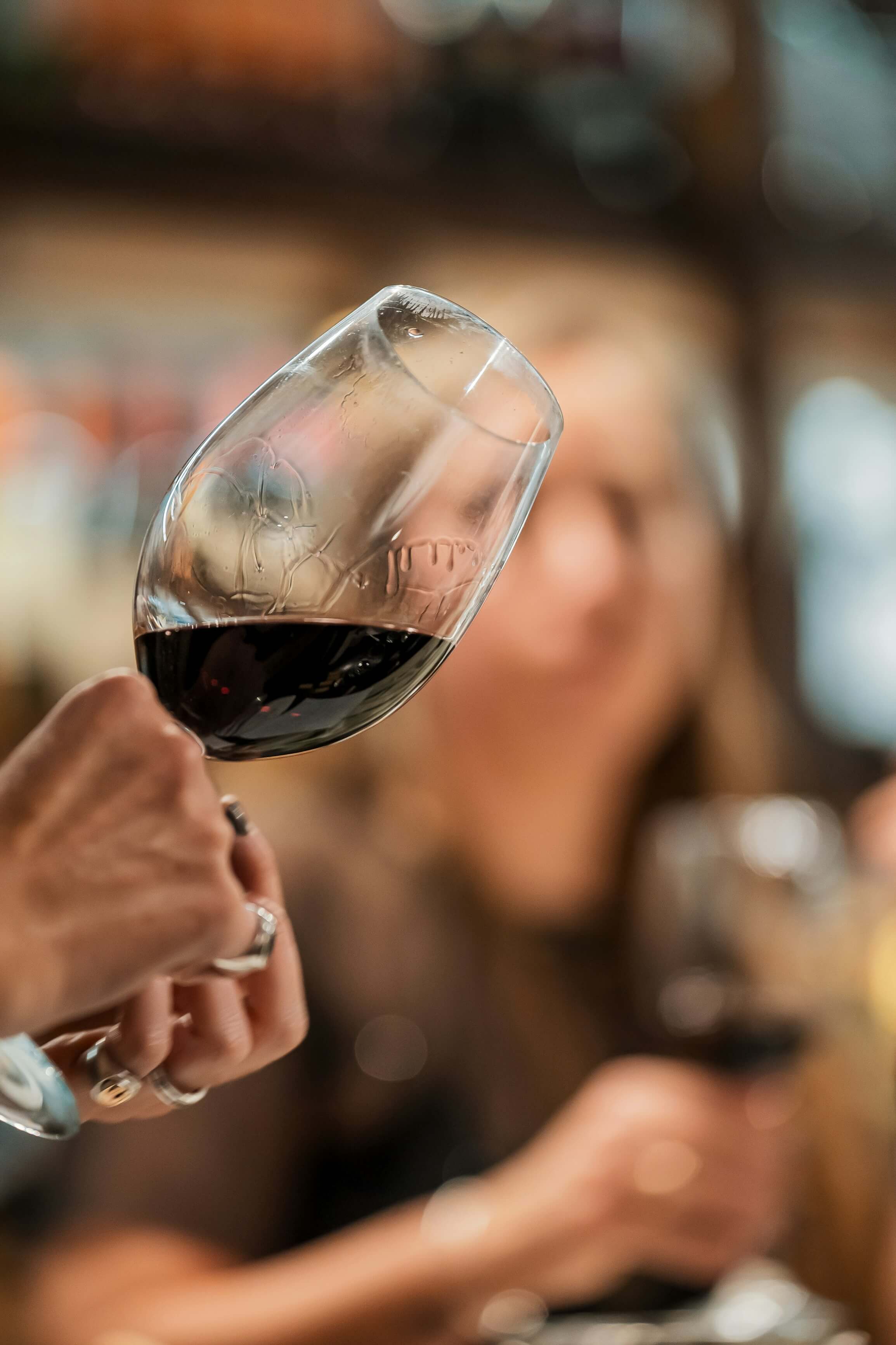 Persona moviendo una copa de vino mientras muestra las cortinas.